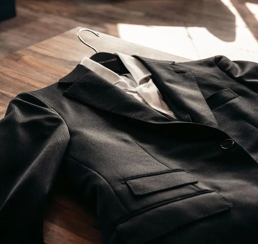 black suit jacket on brown wooden table